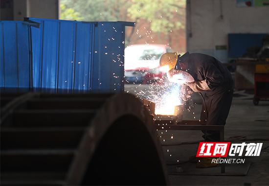 2月21日，长沙市开福区，中铁五局三环机械厂厂房内，员工按防疫要求佩戴口罩作业。