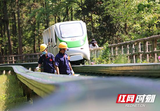 5月1日，湖南张家界武陵源景区十里画廊观光电车巡检员在检查电车运行情况，并要求戴口罩。吴勇兵 摄