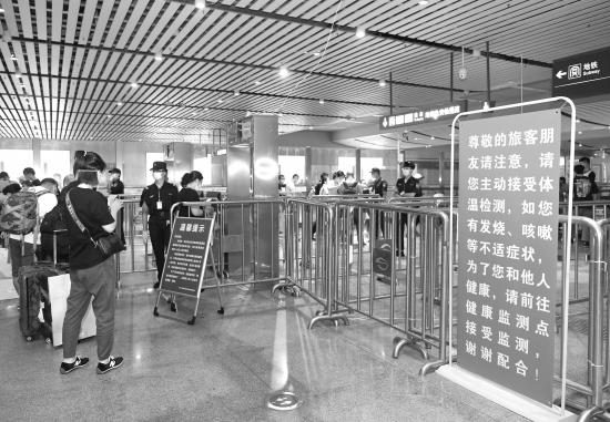 6月15日,长沙火车南站,准备出站的旅客正在扫码,他们还将接受体温检测才能出站。图/记者杨旭