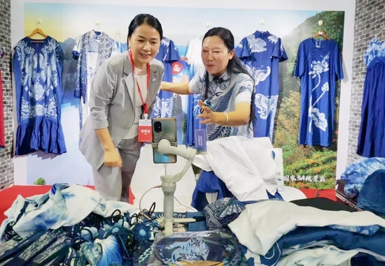 △在湘西扎染展区,向汝莲跟观看直播的网友发出邀约,欢迎全国网友来湘西旅游