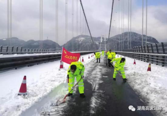 △近日，湘西吉首矮寨大桥，工作人员正在桥面上铲除积雪。