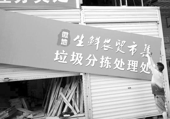  7月1日，长沙市雨花区微地生鲜农贸市集，工作人员正在悬挂垃圾分拣处理处的牌子。 图/受访者提供