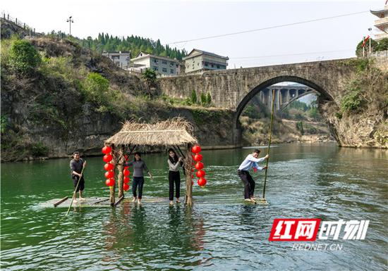  　　青山环抱、绿水奔流中，游客体验竹排竞渡。