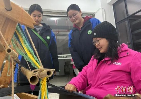  张甜甜在张家界旅游职业学校向学生传授土家织锦技术。杨水莲摄