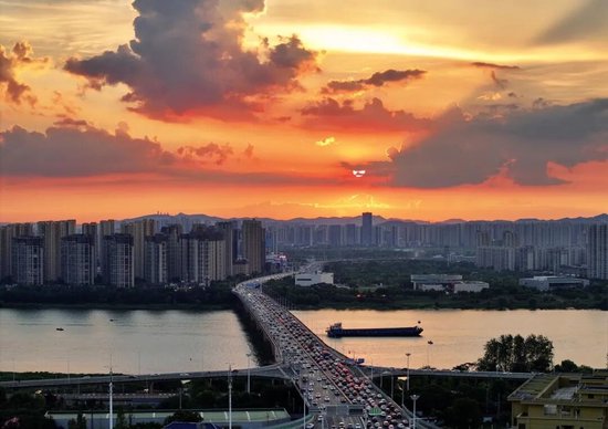 长沙市湘府路高架上空上演火烧云景象。图/童迪