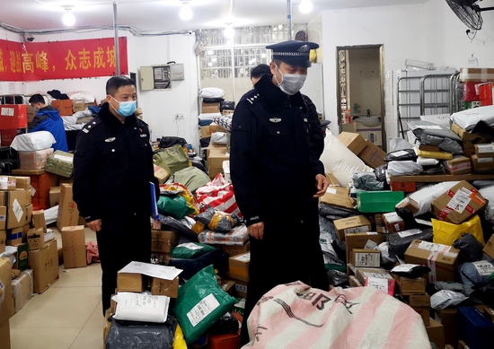 董伟(右一)和同事来到一处快递网点,对相关防疫工作进行督导、检查。 长沙市公安局 供图