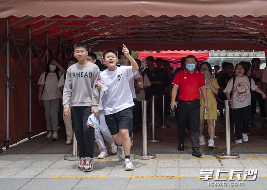 散考后,一位考生比出“第一”的手势第一个冲出校门。长沙晚报全媒体记者 郭雨滴 摄