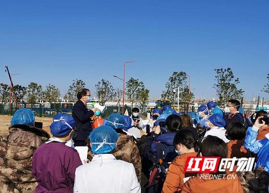 吴安华在户外为雷神山医院医疗队进行培训讲课。