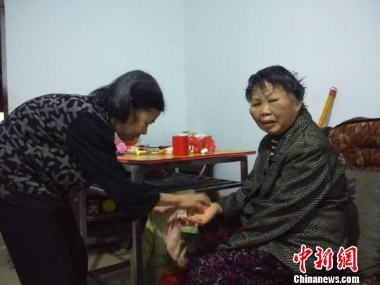 李新彩老人(左)帮张满英洗脸。 谢丽萍 摄