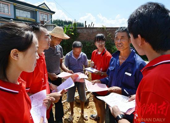 ↑2018年7月16日,洪江市雪峰镇两溪口村一建筑工地,大学生志愿者在为农民宣讲维权知识,帮助他们增强依法维权意识。(资料图片)杨锡建 摄