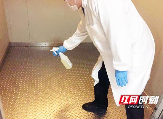 在长沙一处酒店,工作人员正对电梯进行消毒。
