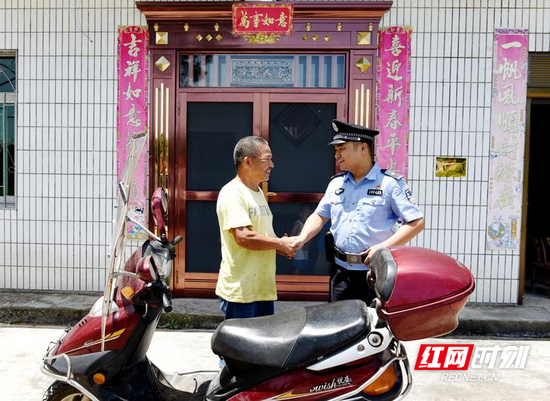 长沙县公安局福临派出所副所长戴炜明（右）将被盗的摩托车追回送还受害人。 盛磊 摄