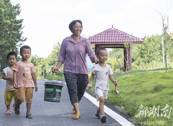 (8月21日,永州市冷水滩区麦子园村,村民何顺琳(右二)提着刚摘的辣椒去卖给泡菜厂。有了泡菜厂,村民的辣椒、豆角、大蒜都不愁销路了。湖南日报·华声在线记者 辜鹏博 摄)