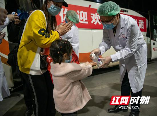医务人员对下车旅客进行检疫消毒。