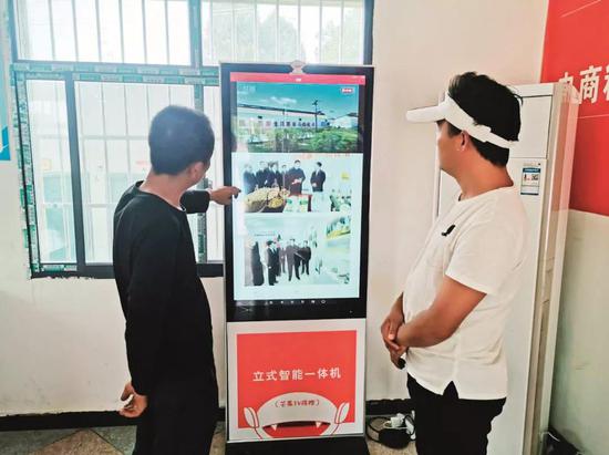 杨木村村民在服务大厅看新闻信息。