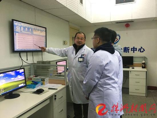 在市三三一医院区域心电诊断中心，心内科副主任、专家谢兴泽（图左）正在为病人进行诊断分析。