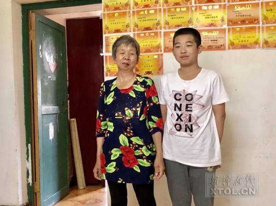 刘立华和胡洋睿在租住的家中,墙上胡洋睿的奖状让刘立华特别欣慰。