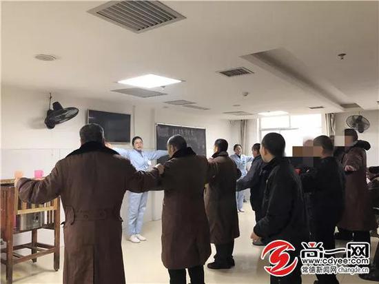 市康复医院一病室活动室内,护师张伟君正在带领男区滞留人员跳操。
