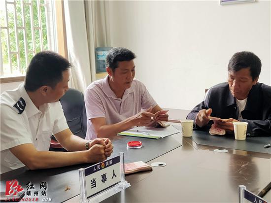 农民工刘丕学等五人接过被拖欠的13000元工资。