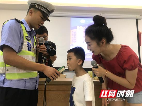 雨花交警与孩子们进行酒精检测仪测试互动。