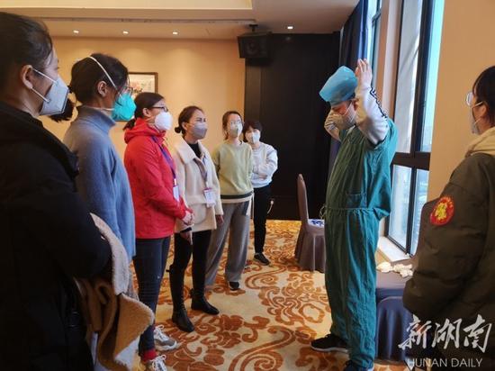 (2月12日下午,湖南对口支援湖北省黄冈市的第三批医疗队五个小分队的队员,在各自驻地进行新冠肺炎第五版诊疗规范、防护服穿脱和戴N95口罩的系统培训。李奇 田魁 摄影报道)