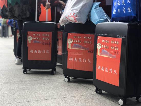湖南医疗队带着统一的行李箱在高铁站等候上车。