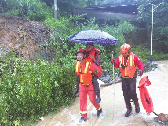 6月24日,怀化洪江区,消防救援人员顶着湍急的水流将一名被困者背至撤离点。