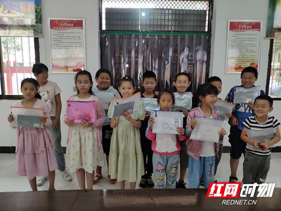 在暑期实践活动中,中南大学湘雅公共卫生学院学子为陕西省长安县留守儿童颁发活动奖品和留影。