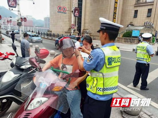 交警检查模特车车主安全帽佩戴情况。