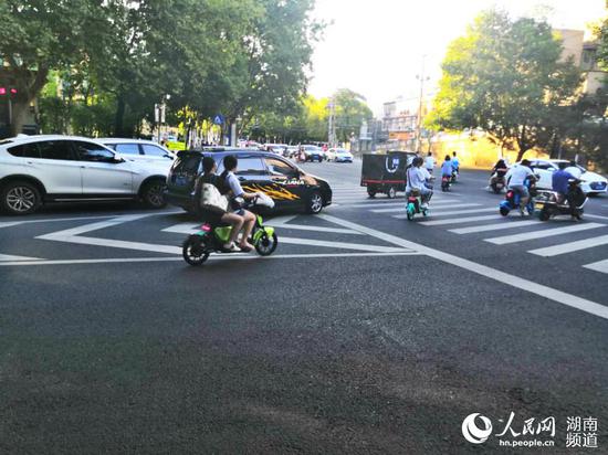 曙光南路路口双人同乘一辆共享电单车。崔雅泓摄