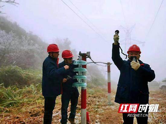 工作人员在进行观冰监测，确保主要设备以最好的状态迎接今年电网负荷考验。