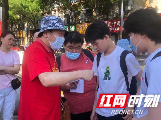 在岳阳市外国语学校考点,送考老师正在细心嘱咐孩子们注意事项。