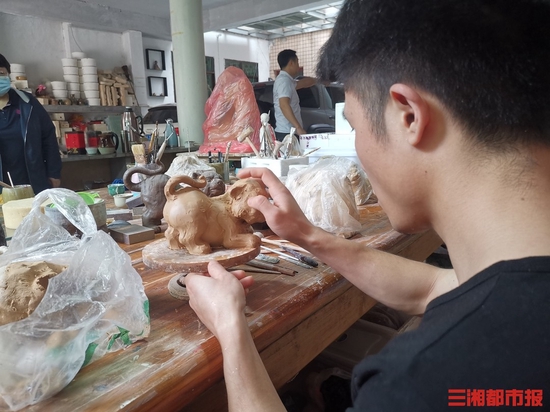(4月25日,长沙泥人刘陶艺有限公司内,工作人员制作产品。)