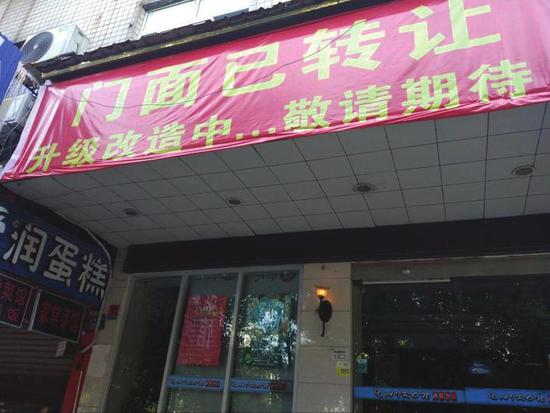 花板桥市场附近的爱润烘培店门头挂起了“门面已转让”的横幅