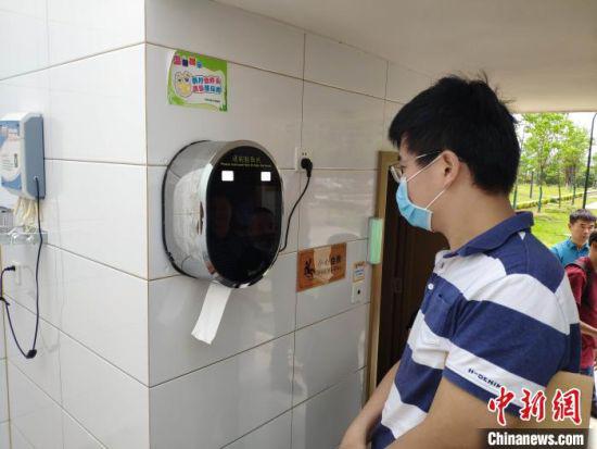 民众体验浏阳公厕里的智能刷脸取纸机。　王昊昊 摄