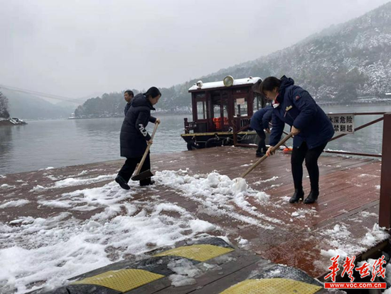 （工作人员在扫除冰雪。景区供图）