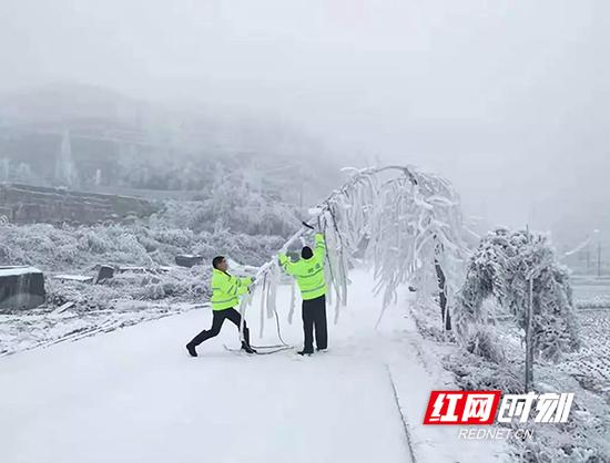 湖南公路部门加大巡查力度，对所辖路线进行24小时巡查，及时发现并清除路障，确保不因冰冻路障影响司乘人员通行。图为隆回县公路局工作人员正在清除路障。