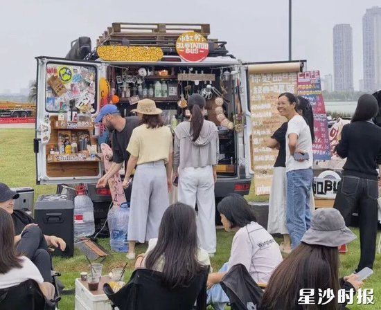 游客边欣赏湖景，边喝咖啡。