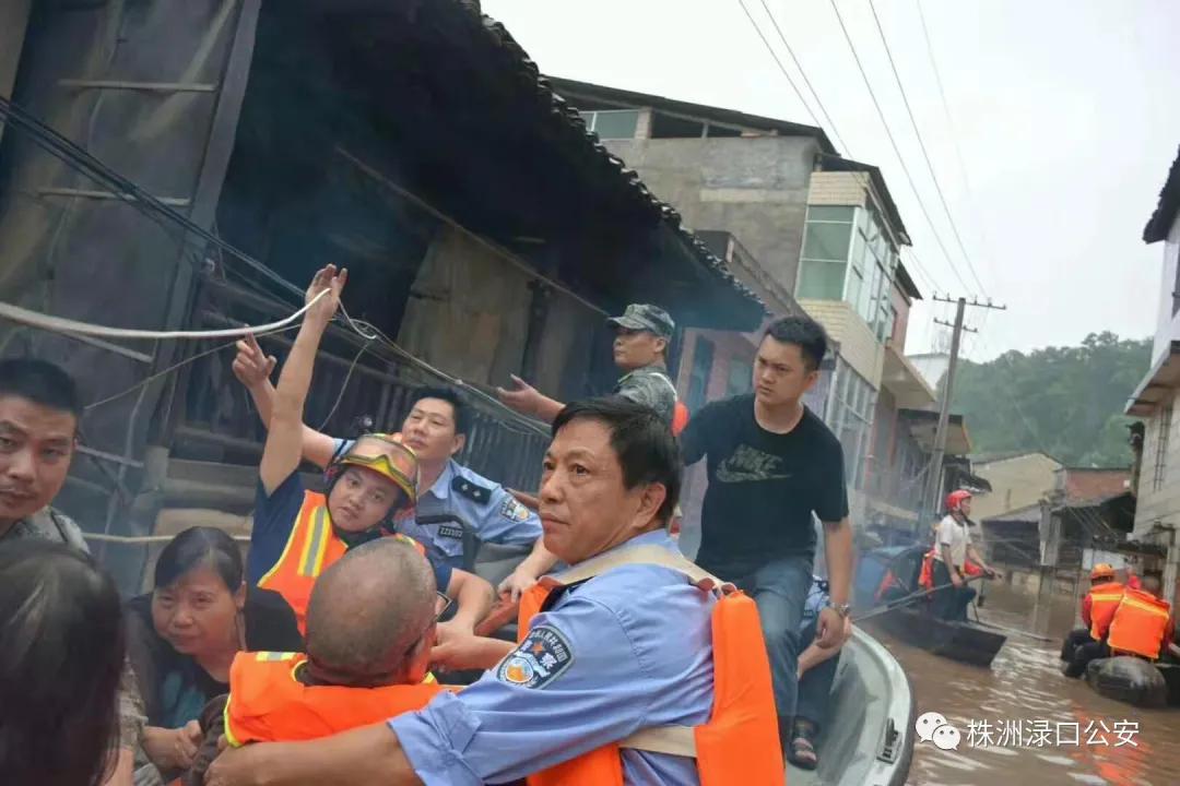 贺天红在洪水中与救援人员一起转移被困群众