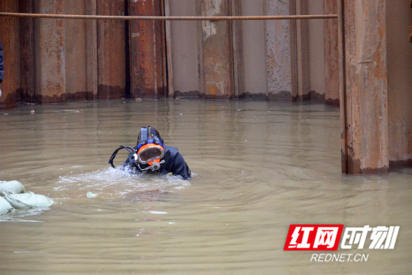 被称作“蛙人”的水下潜水作业者钱德权，正在0℃以下的冰水里对围堰钢板桩查漏补缺。