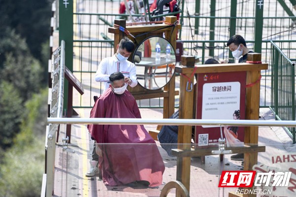 在景区内,理发师为游客和复工员工理发