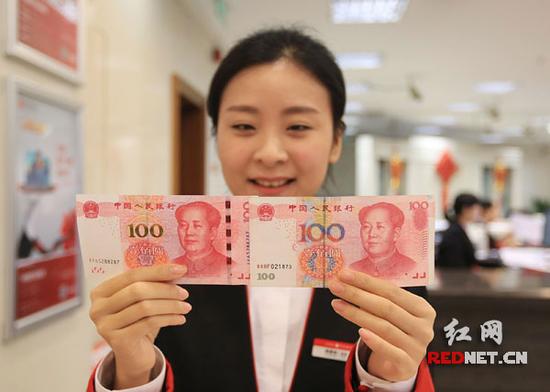 中信银行长沙分行工作人员向时刻新闻记者展示2015年版第五套人民币100元纸币。