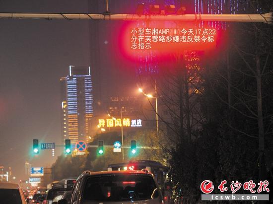 　　昨晚，芙蓉中路松桂园路口，一块电子显示屏正滚动播放不久前发生交通违法车辆的车牌号码、违法时间和地点。　　长沙晚报记者 邹麟 摄