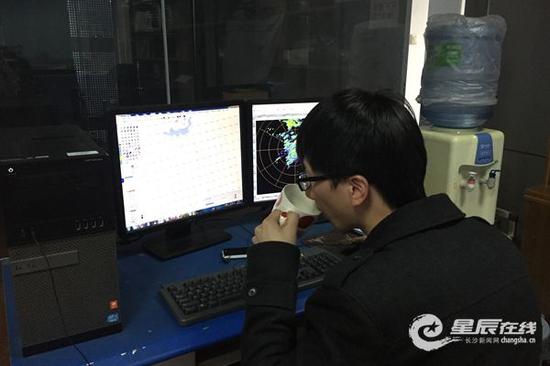 (在长沙市气象台,工作人员对传送回来的数据进行分析。)