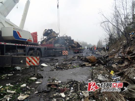 20日清晨，施救清障队伍用吊车清理路面，水泥块、货车零部件散落一地。