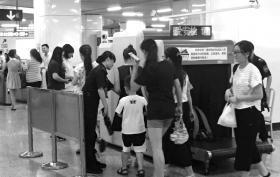 7月25日,地铁1号线五一广场站,进站的乘客在过安检。