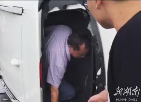 青年踹开汽车玻璃后,帮助被困人员迅速逃生。
