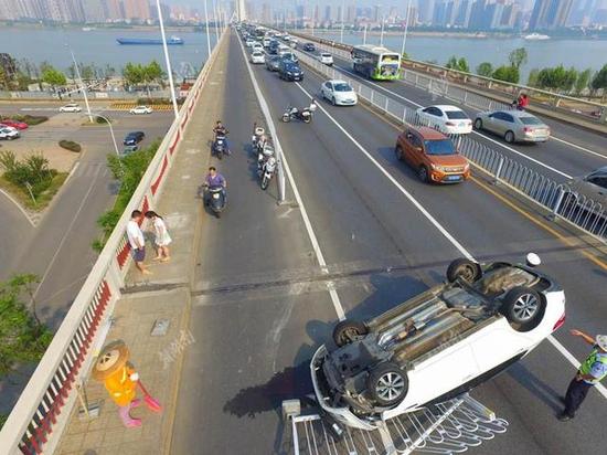 长沙一司机开车分神 致轿车撞上护栏翻车