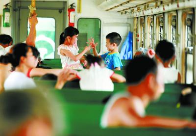 4、2014年7月6日，两位小朋友在车厢里玩起了游戏，享受列车的快乐之旅。（资料图片）本版照片均为湖南日报记者郭立亮摄