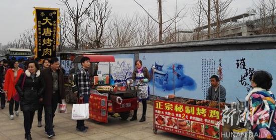 
	1月1日，城铁先锋站前施工围挡旁的行人道上，小摊小贩吆喝生意。邓晶琎 摄
